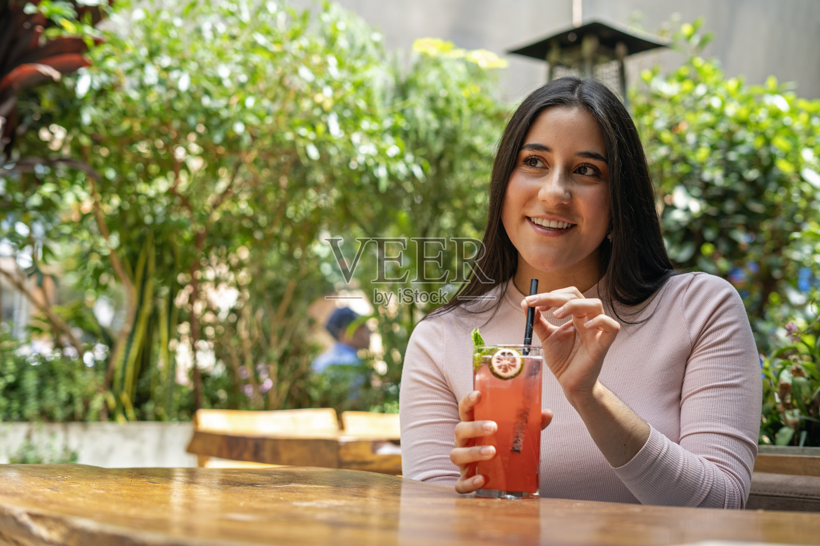 在餐厅喝苏打水的女人。照片摄影图片