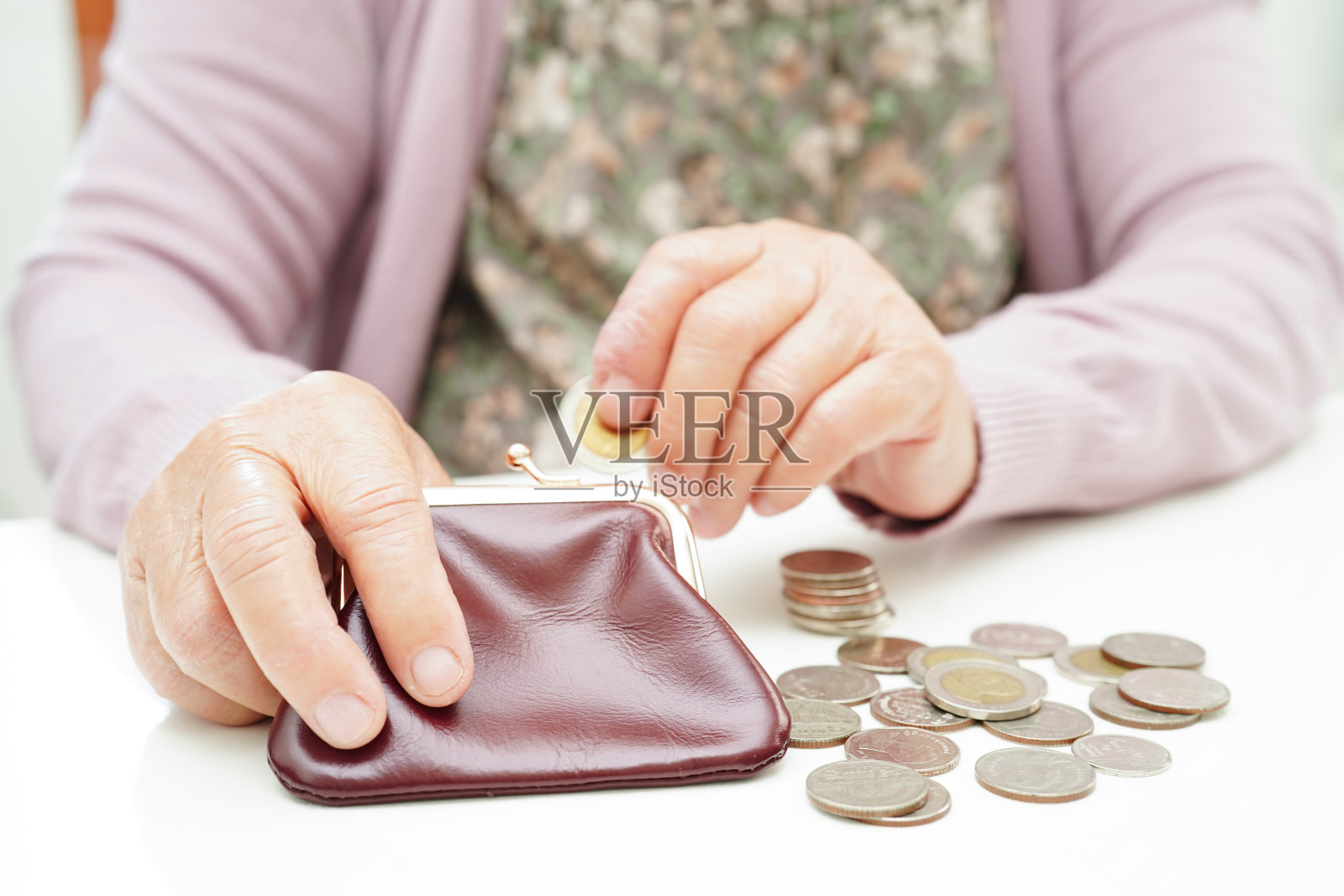 退休的老妇人数着硬币钱，担心每月的开支和治疗费的支付。照片摄影图片