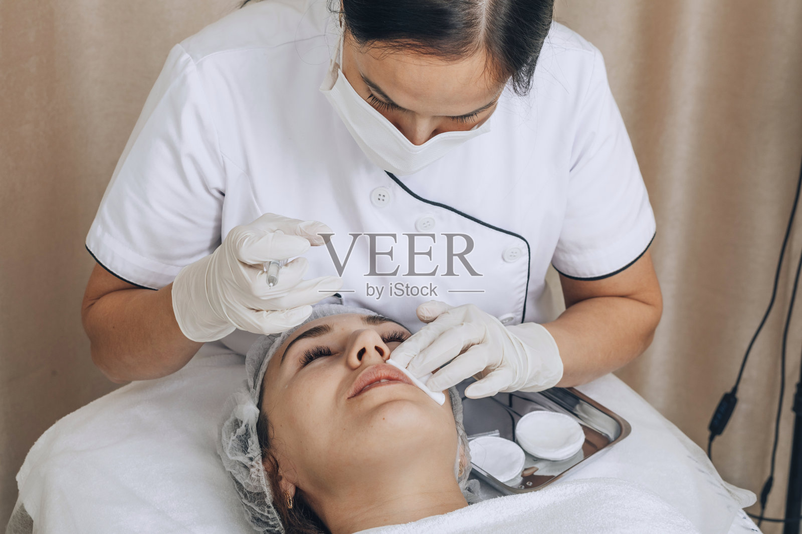 专业的美容师在工作中，轻轻地在客户的脸上进行治疗，细致的皮肤护理照片摄影图片