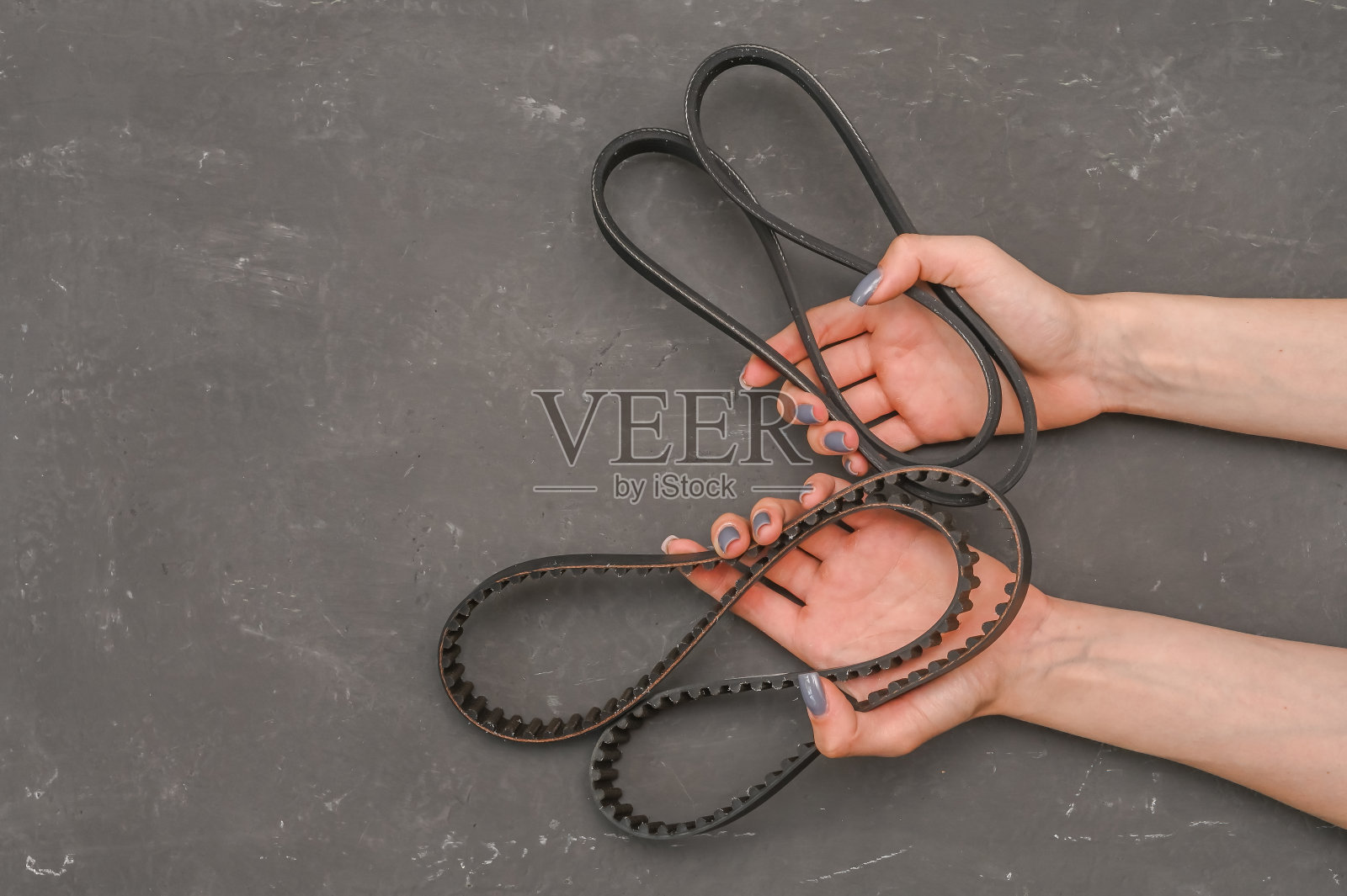 汽车安全带在你手中。在灰色背景上照片摄影图片