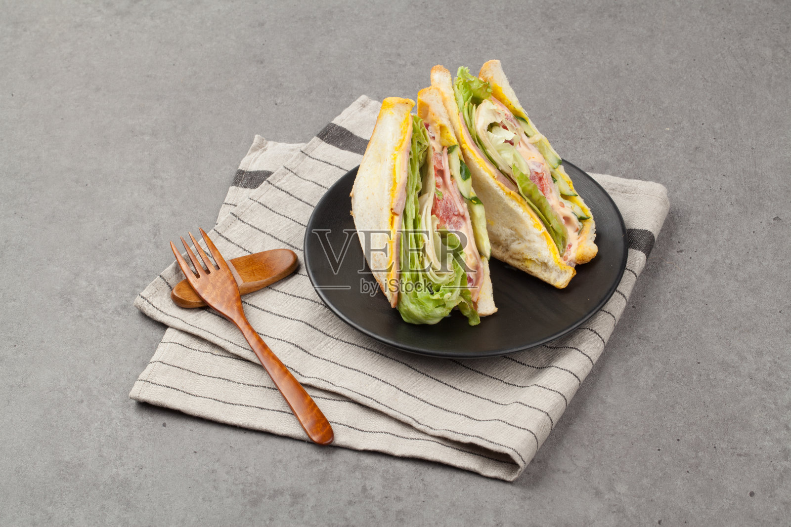 三明治是一种把肉、鸡蛋、奶酪、蔬菜等放在两片涂有黄油或蛋黄酱的薄片面包上做成的食物。照片摄影图片