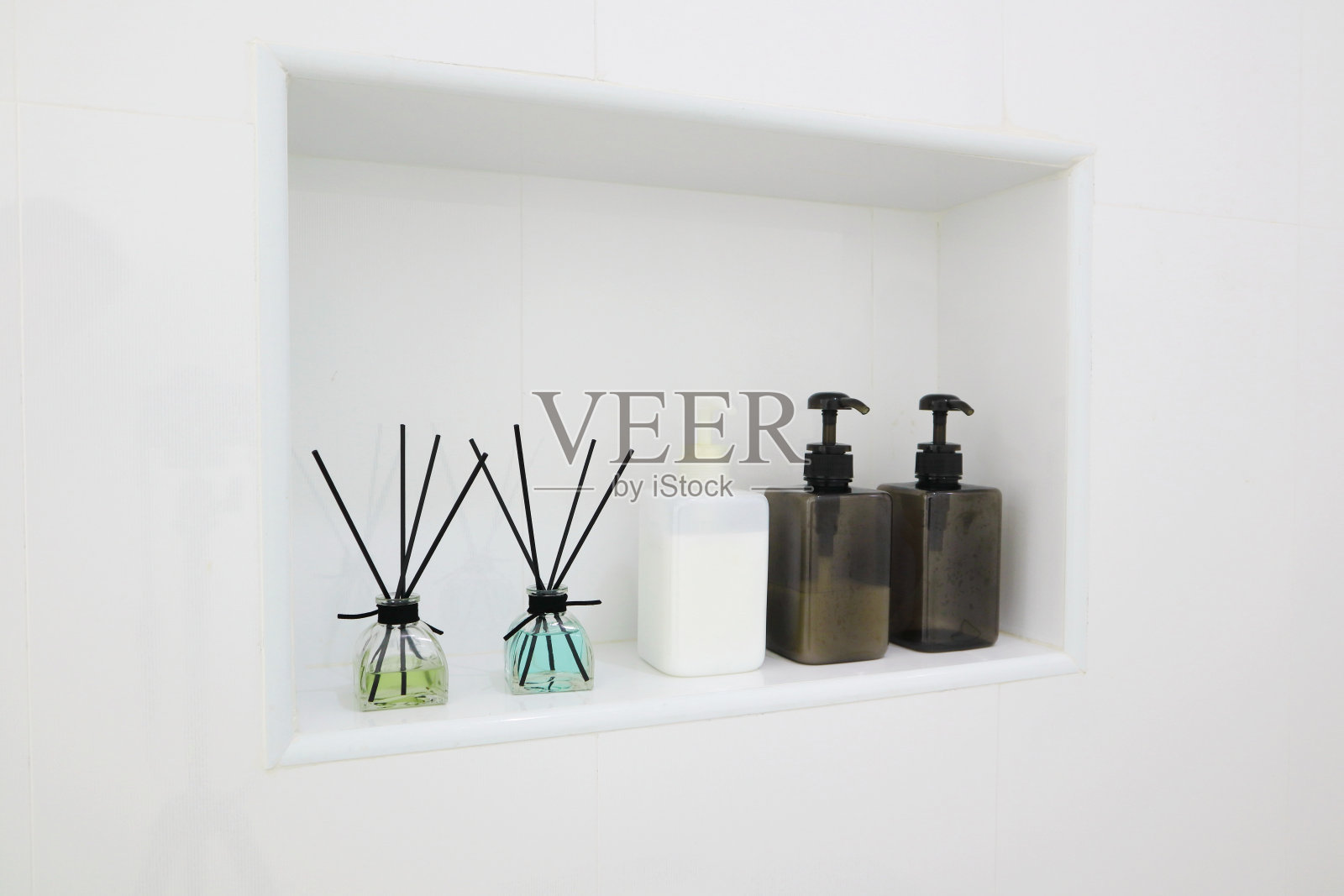 豪华香氛扩散瓶在漂亮的白色桌子架子作为房间清新剂在卫生间浴室照片摄影图片