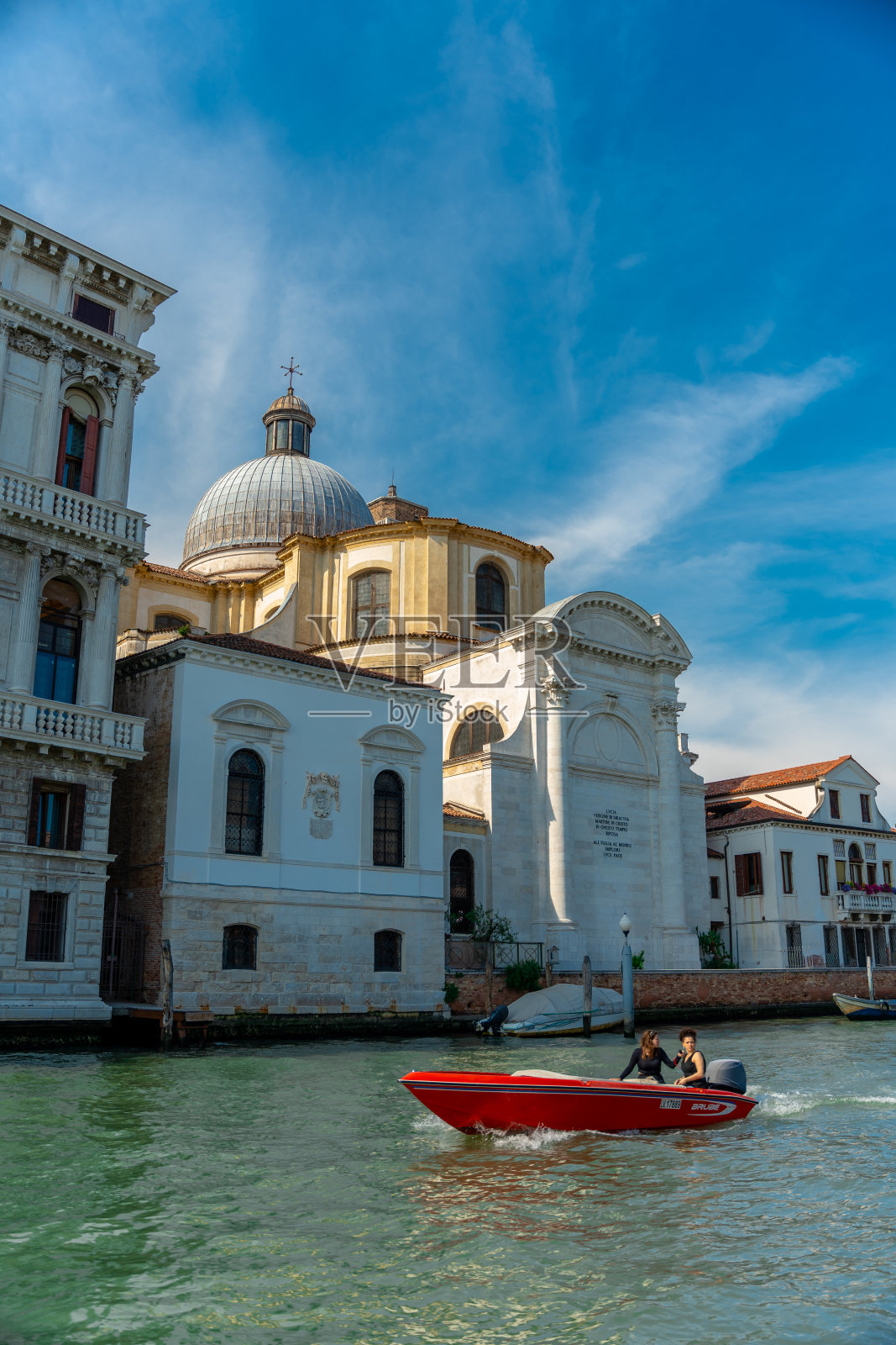 威尼斯运河美景，快艇和历史悠久的圆顶教堂。照片摄影图片
