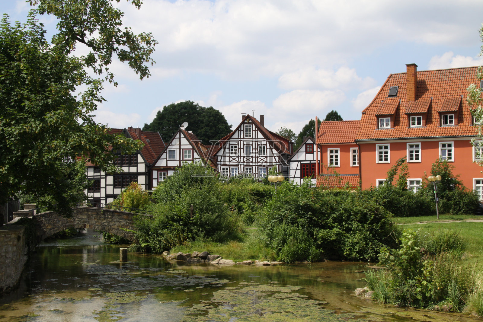 半木结构的房屋，前景是帕德河的泉水，帕德伯恩，德国北部，照片摄影图片