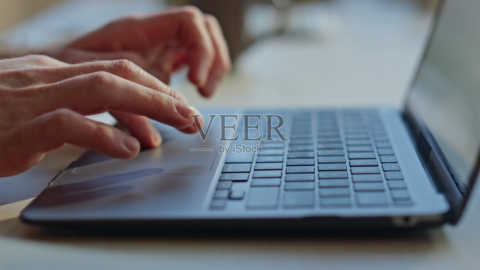 男子双手打字键盘笔记本电脑在办公室的特写。男人的手指工作照片摄影图片