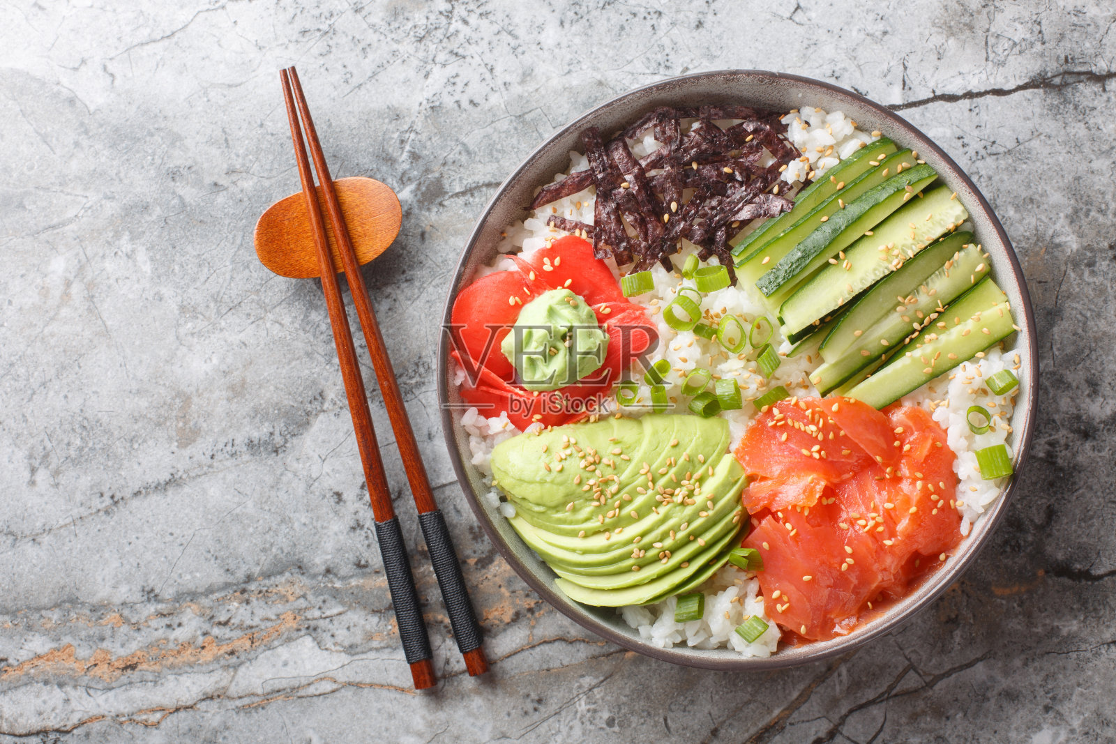 米饭寿司碗，三文鱼，鳄梨，黄瓜，葱，海藻，腌姜和山葵特写。水平俯视图照片摄影图片