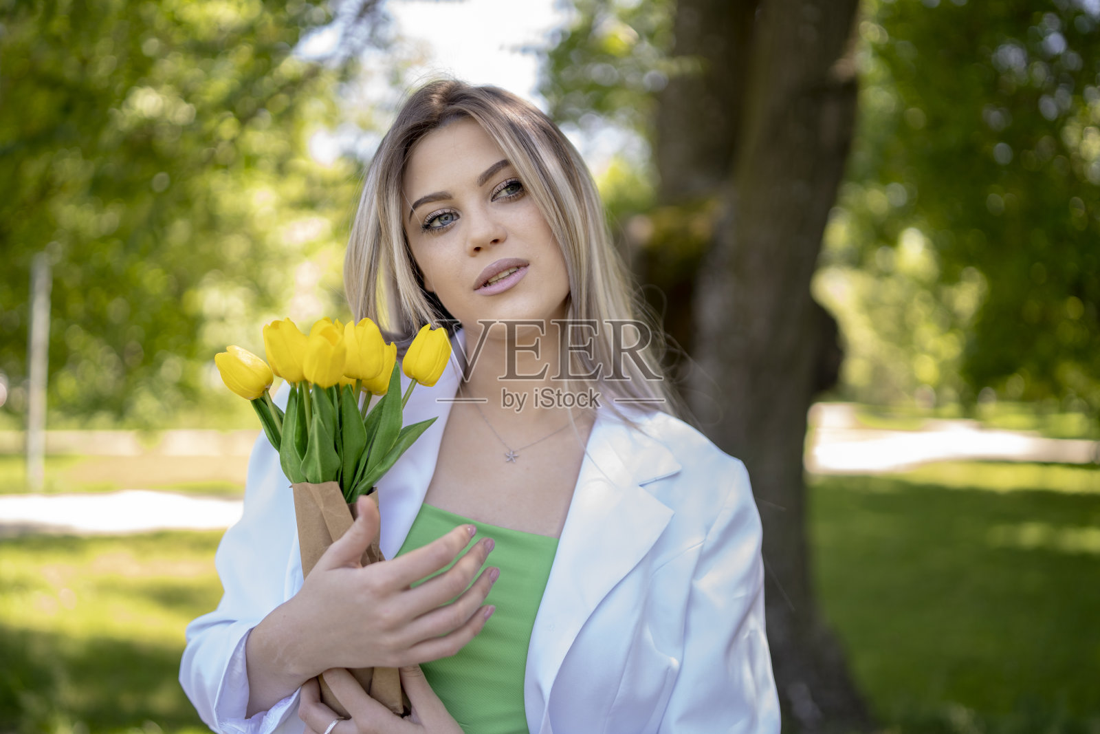 年轻漂亮的黑发女人拿着一束郁金香花照片摄影图片