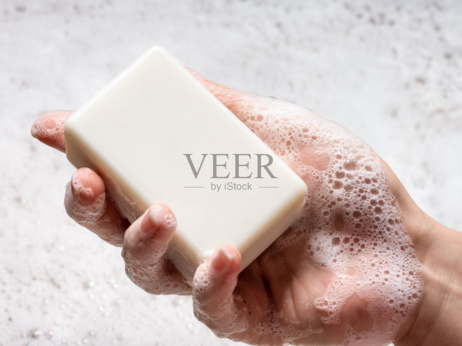女人手里拿着泡沫肥皂。照片摄影图片