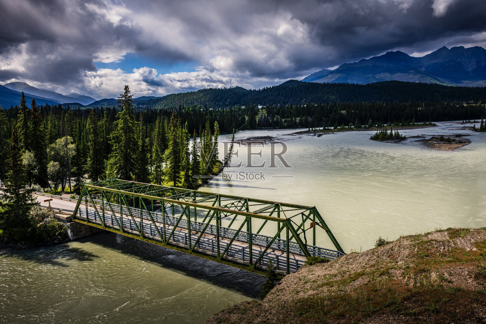 位于加拿大阿尔伯塔省一条蜿蜒河流上的一座桥照片摄影图片