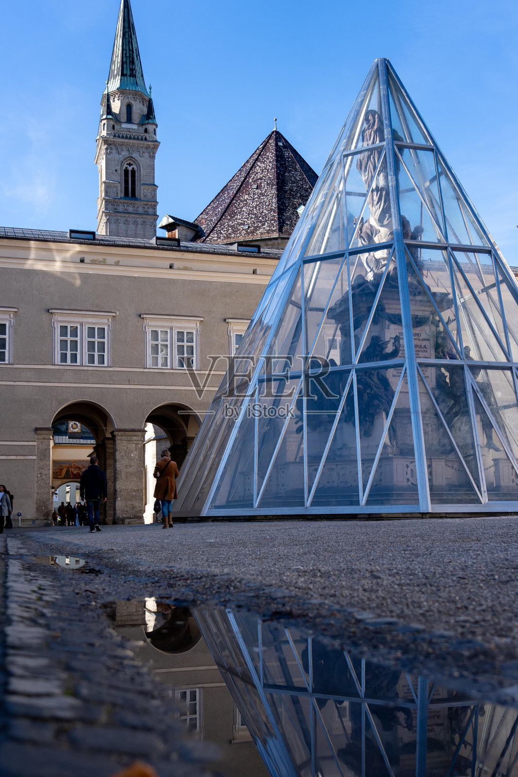奥地利萨尔茨堡,一座玻璃金字塔包裹着一座雕像。照片摄影图片