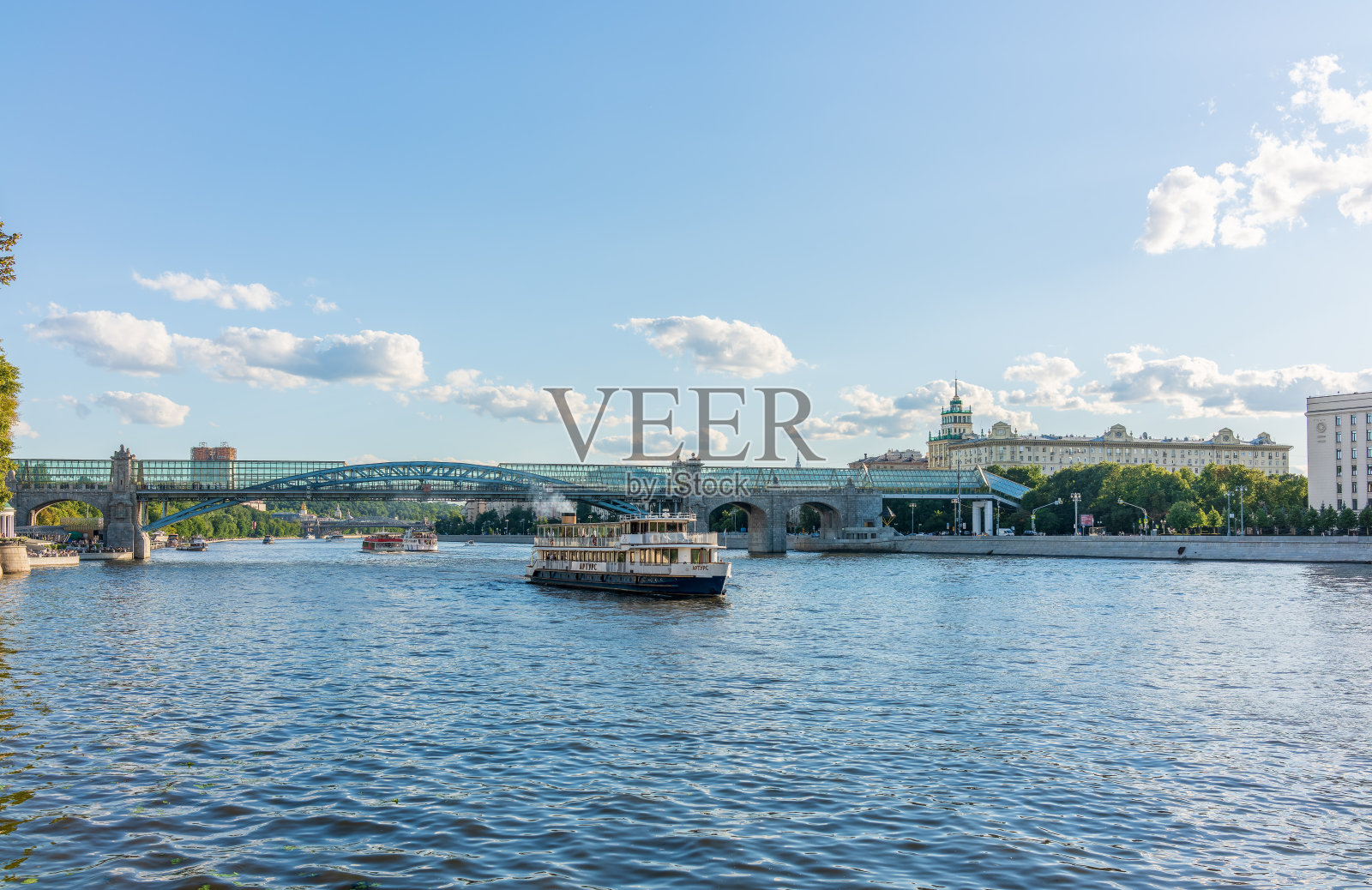 夕阳下的莫斯科河堤、普希金斯基大桥和游船。照片摄影图片