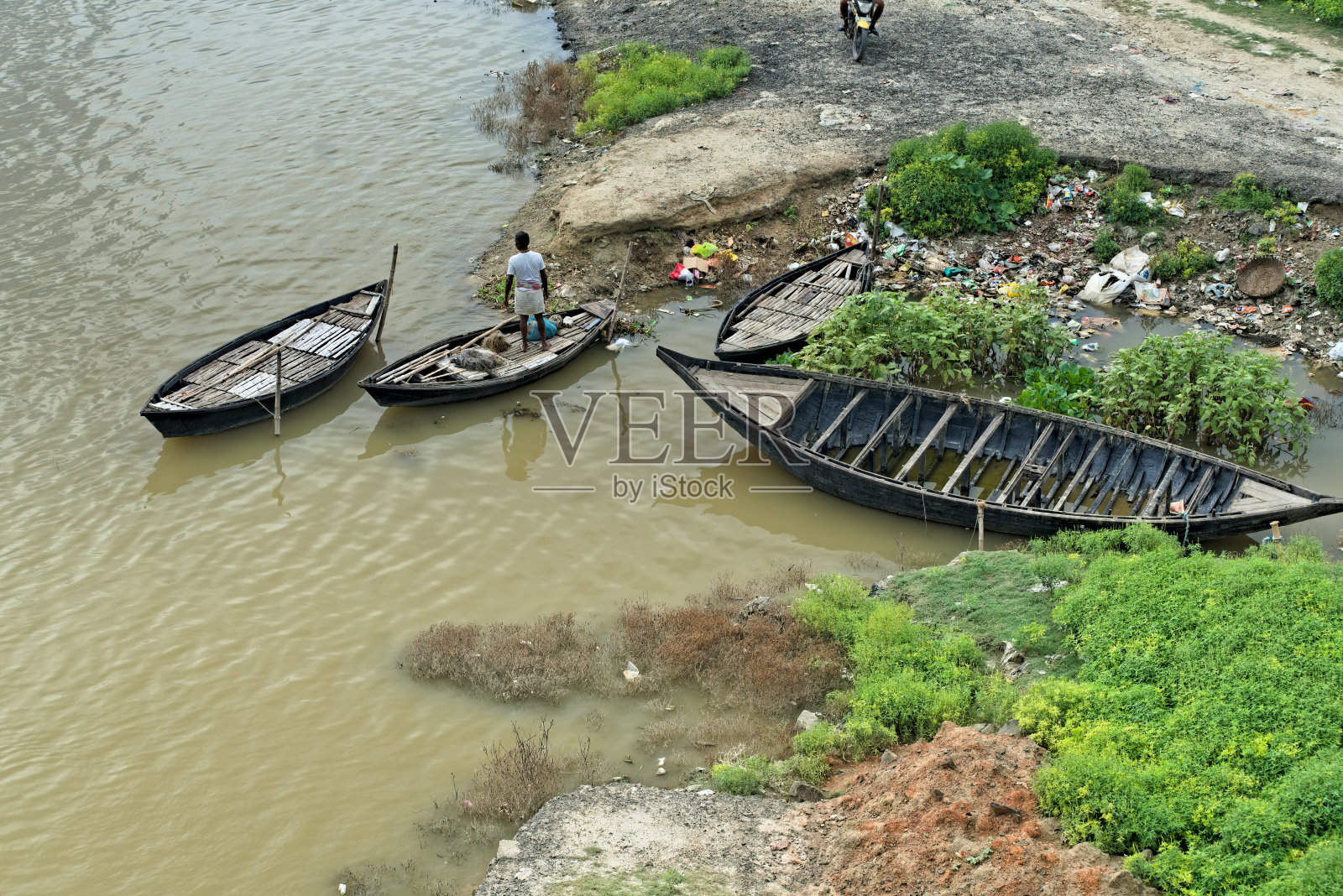 印度的Mahananda河岸边，木船被绑在岸边照片摄影图片