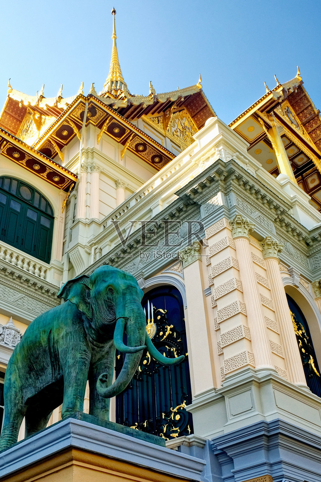 在一个装饰华丽的建筑之前，一个巨大的大象雕塑占据了舞台的中心，它被放在一个有着复杂图案的基座上。照片摄影图片