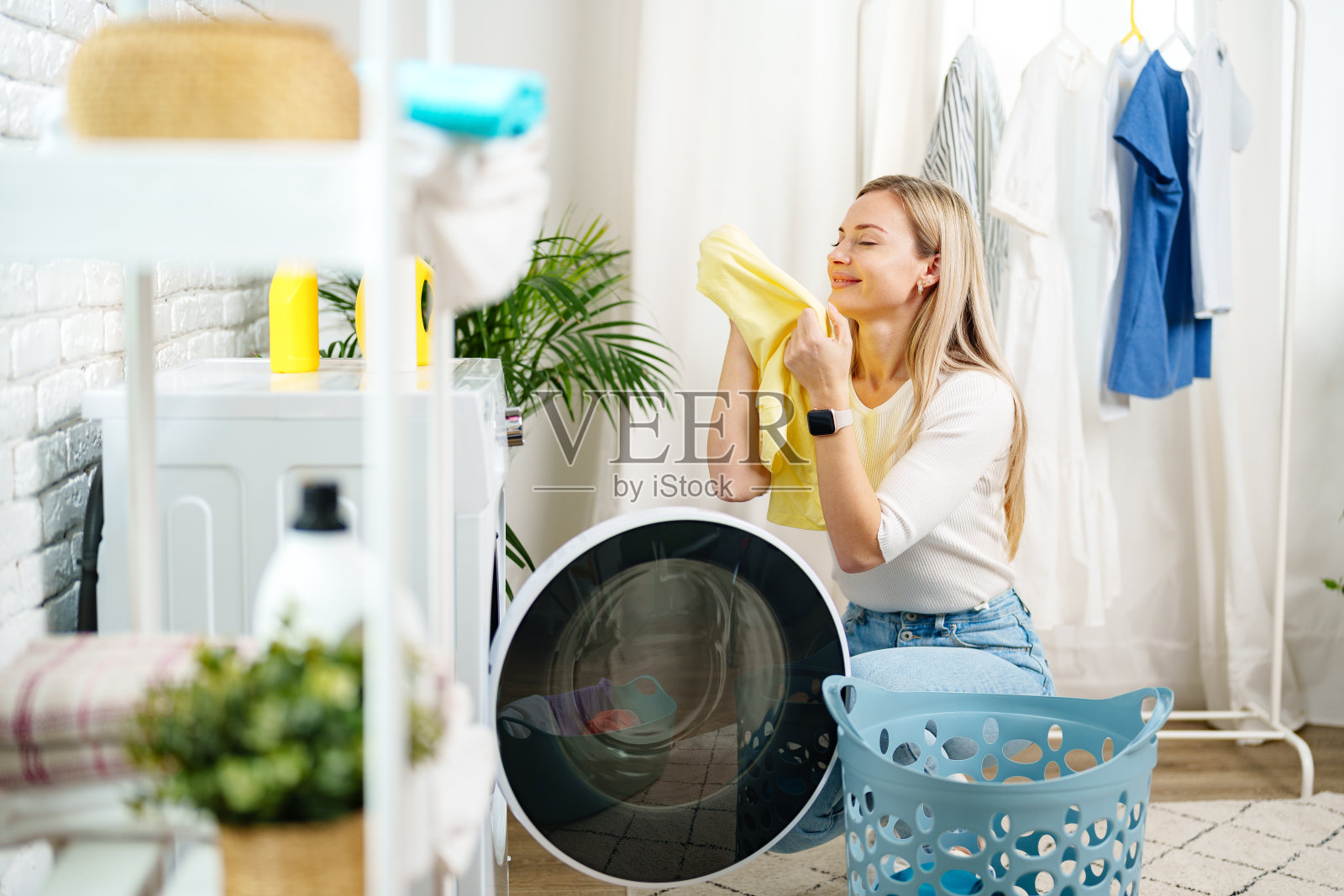 在洗衣机旁洗衣服的妇女照片摄影图片
