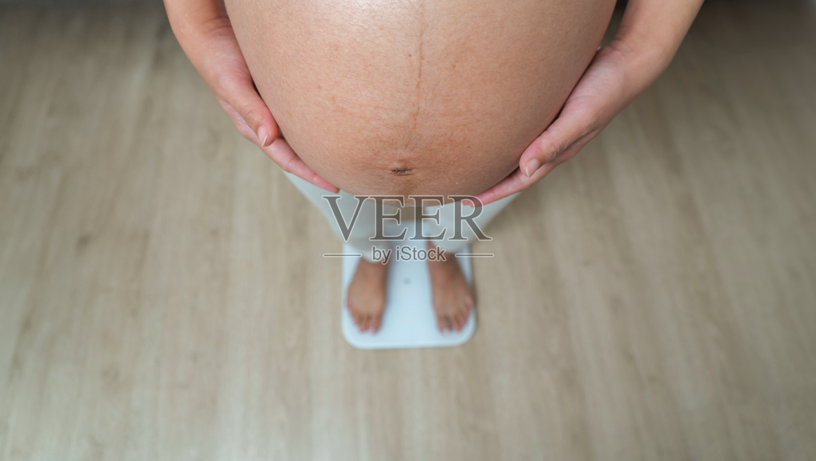 一幅幸福的亚洲孕妇在家里卧室里增重的肖像。生孩子了。家庭人的生活方式。妈妈的爱。照片摄影图片