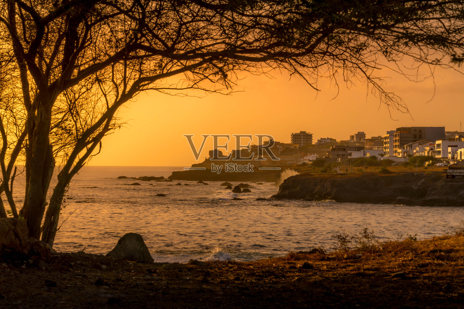 圣地亚哥岛上佛得角群岛首府普拉亚的全景，日落时分，大西洋上橙色的天空和海浪。照片摄影图片