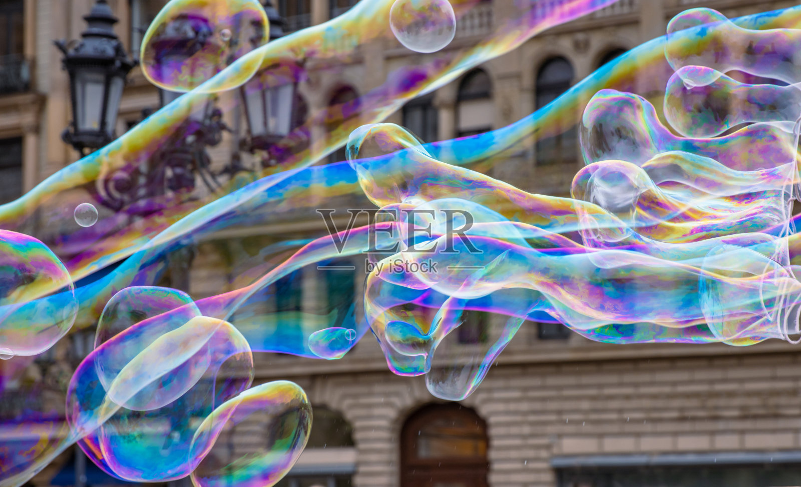 在刮风的日子里，许多五颜六色的巨型肥皂泡在空中飞舞。巨大的气泡在风中伸展成长而平滑的变化形式，而不会破裂。关闭了。副本的空间。有选择性的重点。照片摄影图片