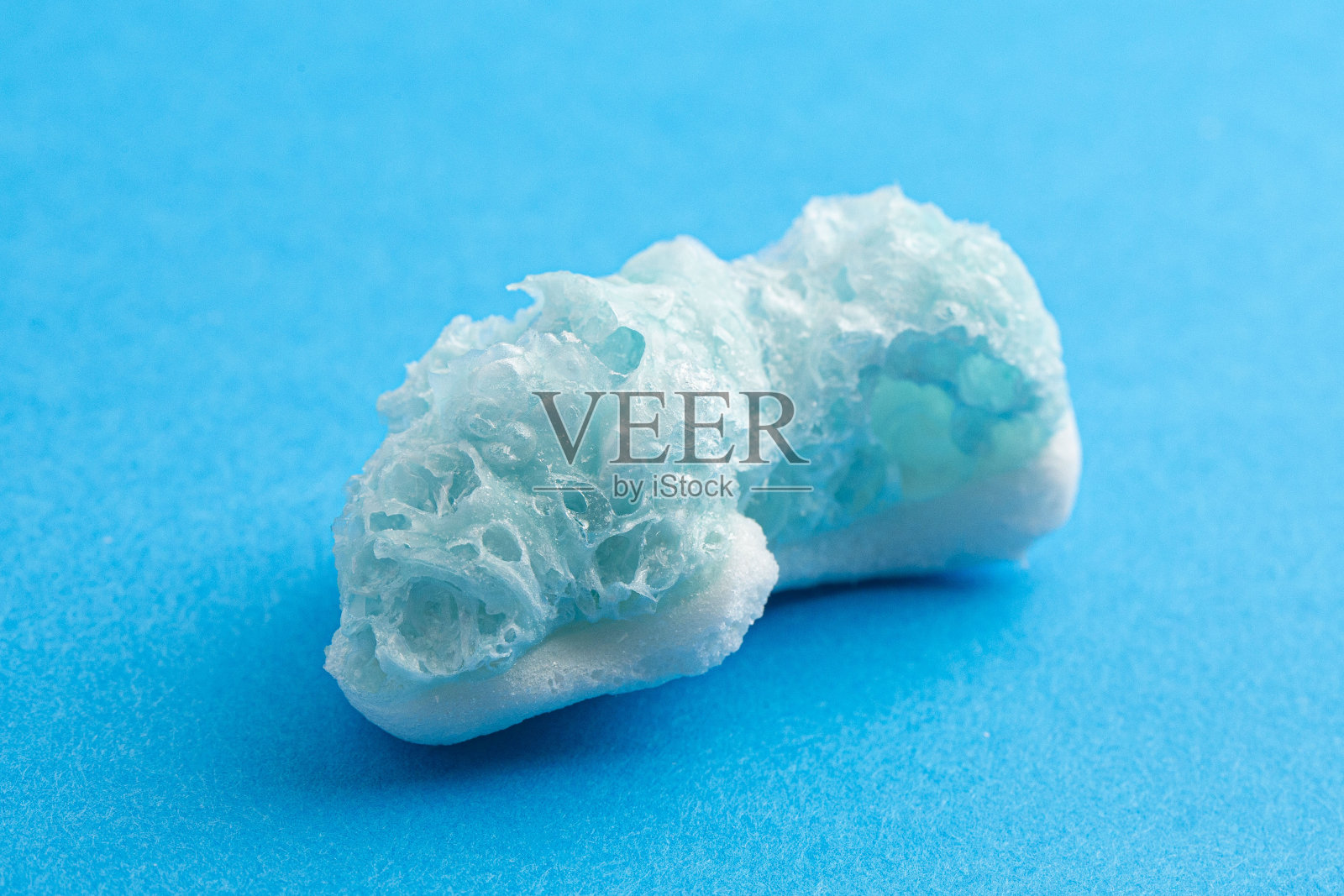 冷冻干燥蓝色软糖形状鲨鱼在蓝色背景照片摄影图片