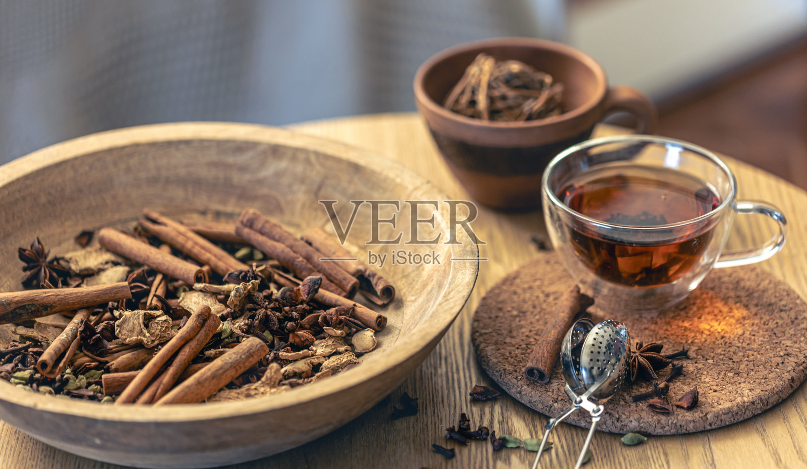 一杯新鲜冲泡的红茶，木桌上不同种类的香料。照片摄影图片