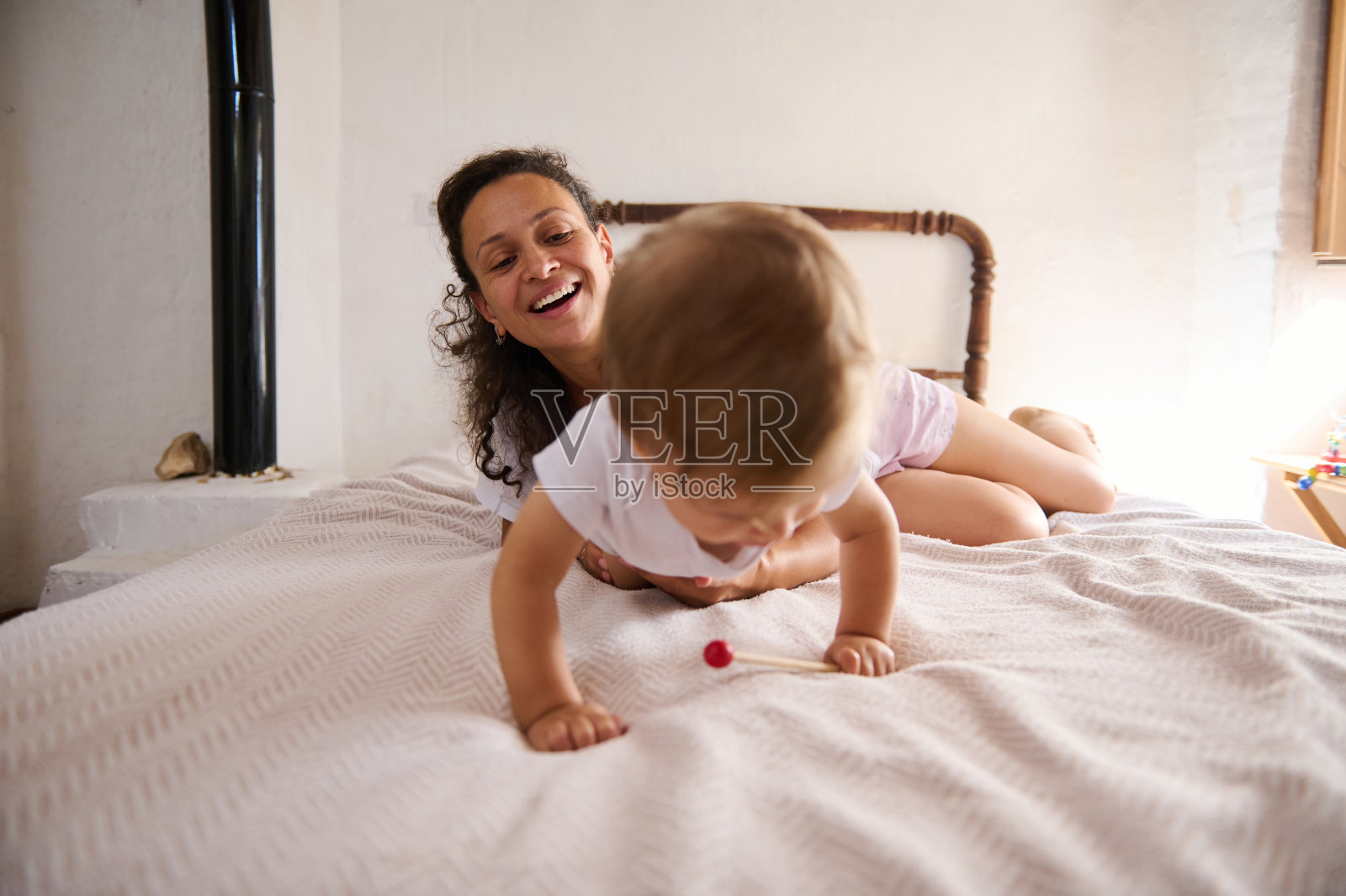 快乐的母亲和婴儿在舒适的房间里玩耍照片摄影图片