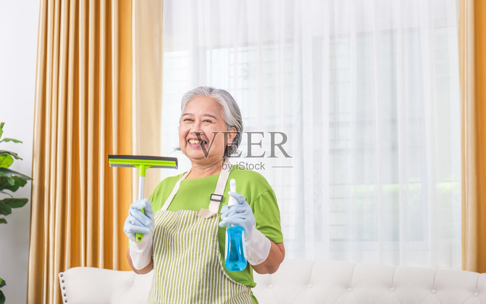 开朗的专业女管家，备有清洁工具，清洁服务，资深女管家照片摄影图片