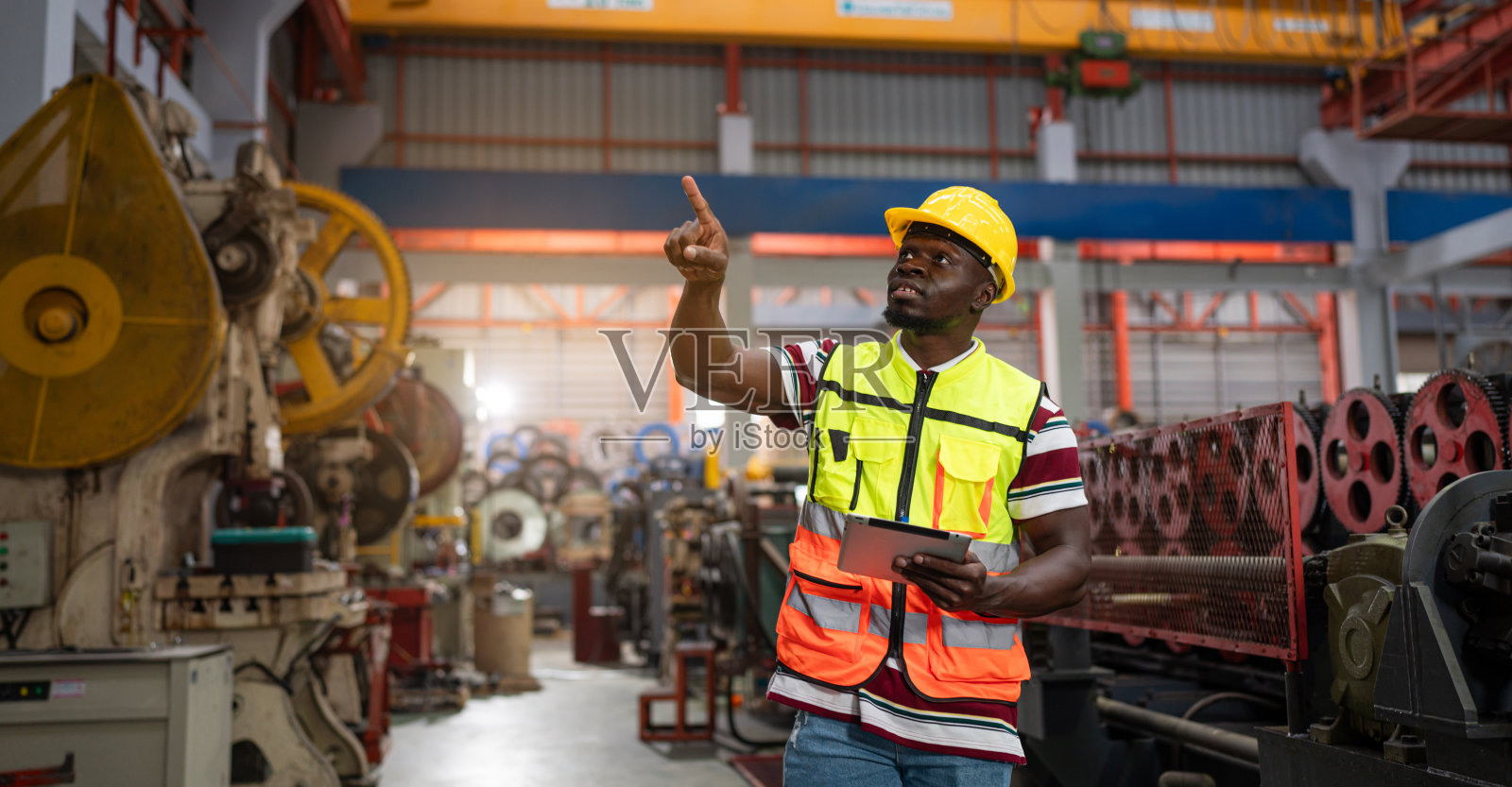 男性工程师或工厂工人使用片剂监控生产输送机。照片摄影图片