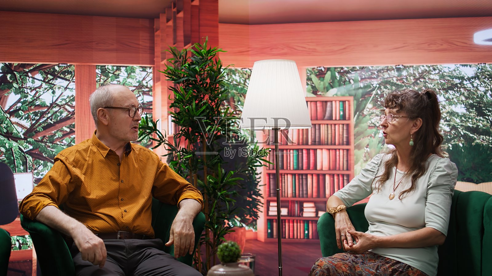 在舒适的家中微笑的老人，在闲暇时谈笑风生照片摄影图片