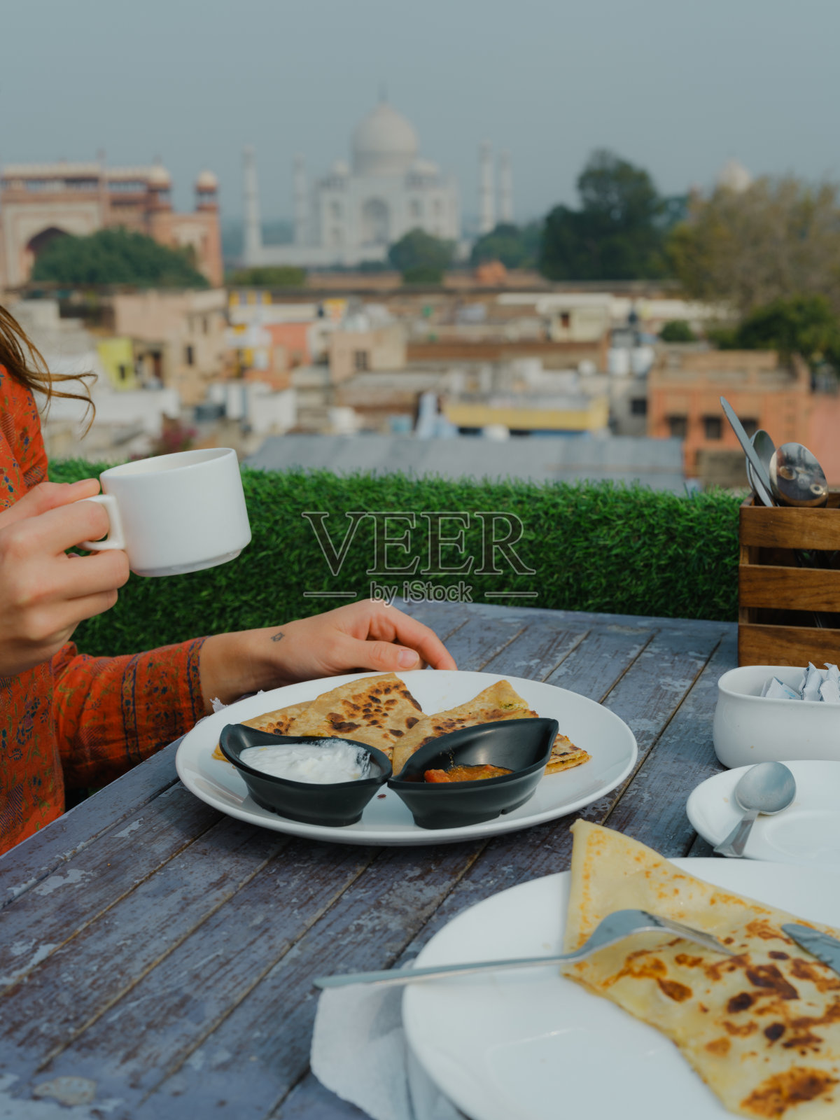 俯瞰印度泰姬陵，享用传统早餐的妇女照片摄影图片