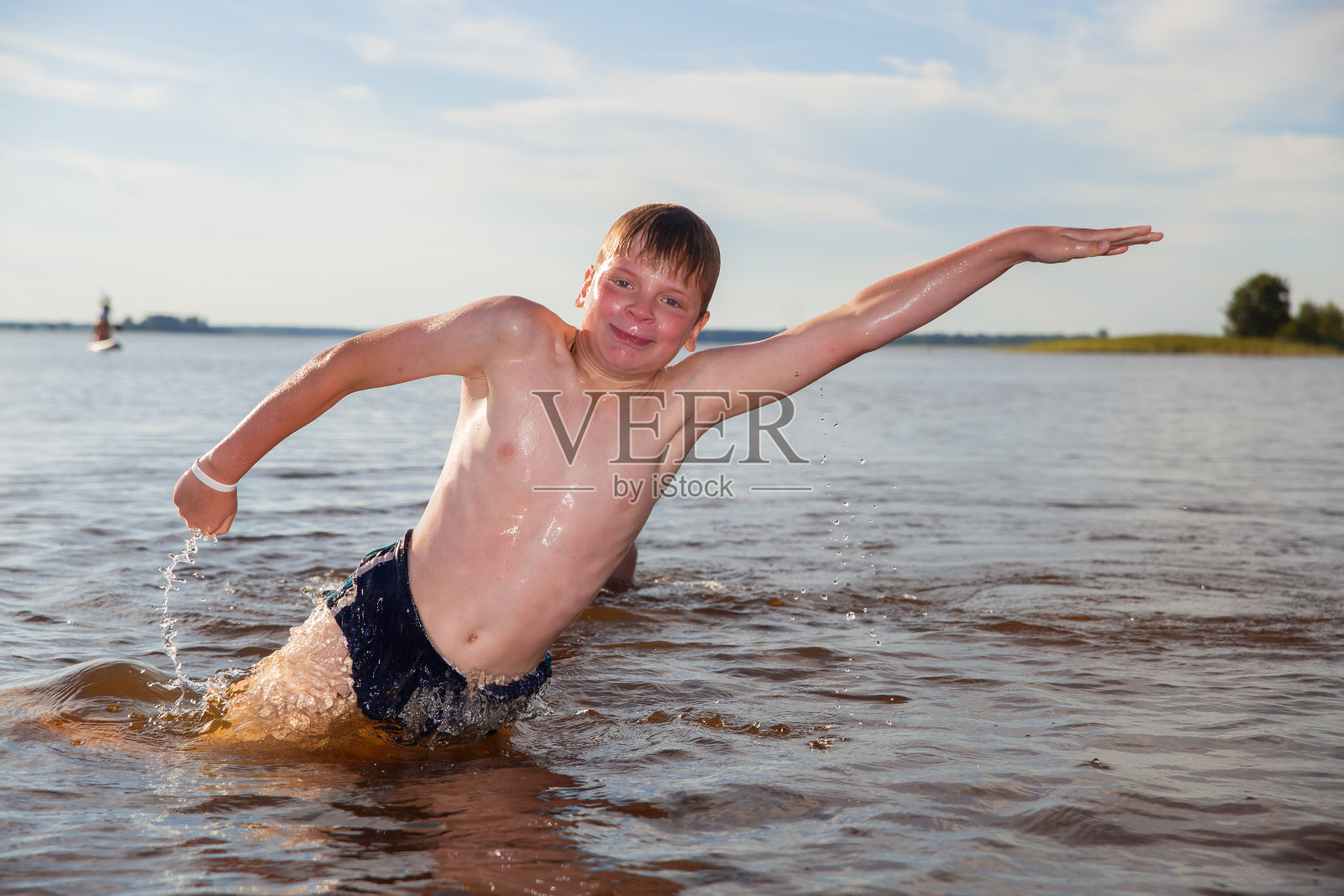 男孩在湖里游泳照片摄影图片
