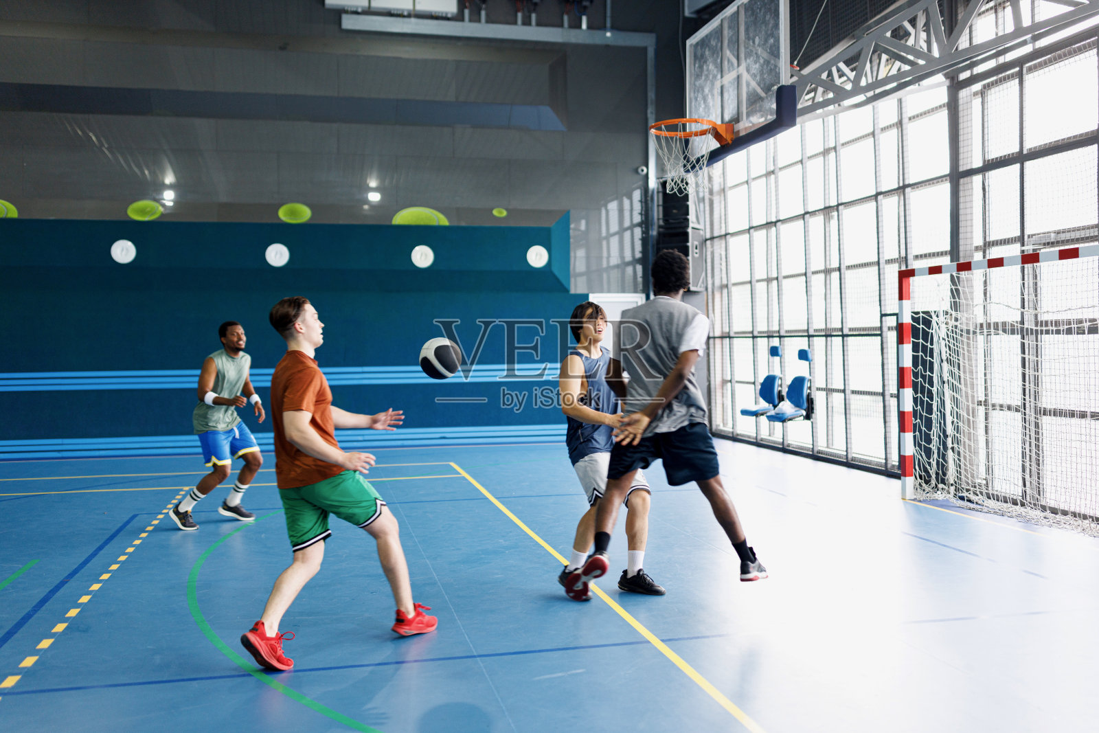 一群不同的朋友在打篮球的时候玩得开心，保持健康照片摄影图片