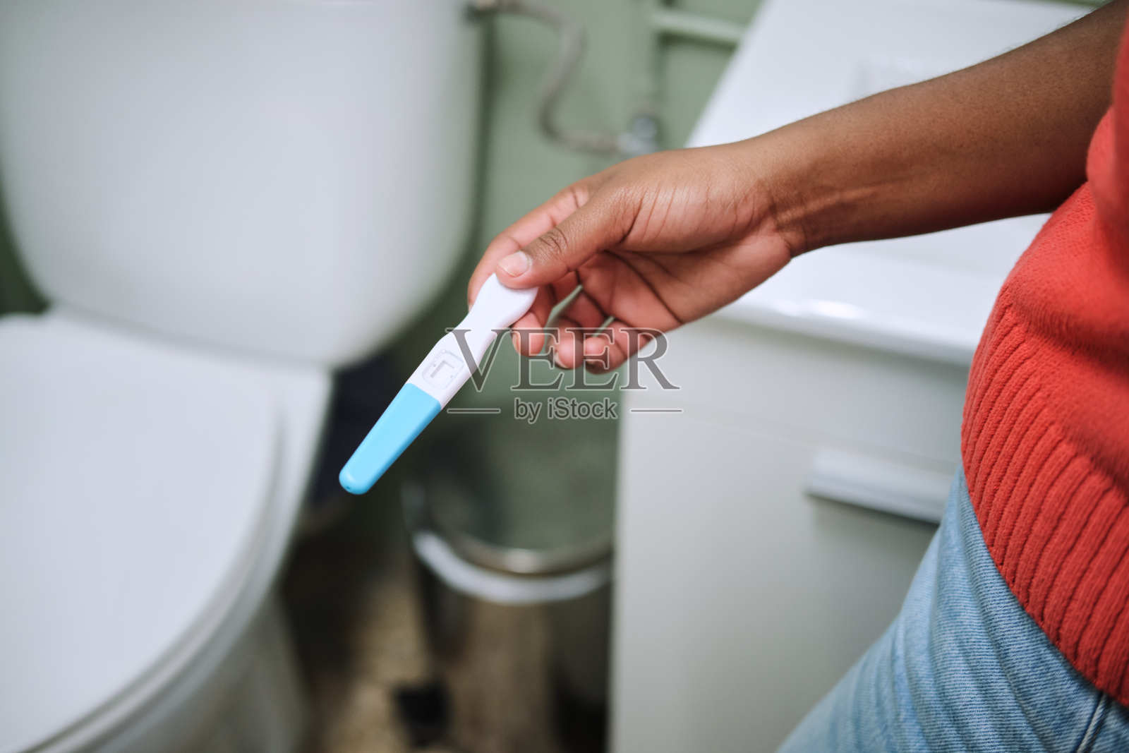 卫生间里黑人手拿验孕棒的特写镜头照片摄影图片
