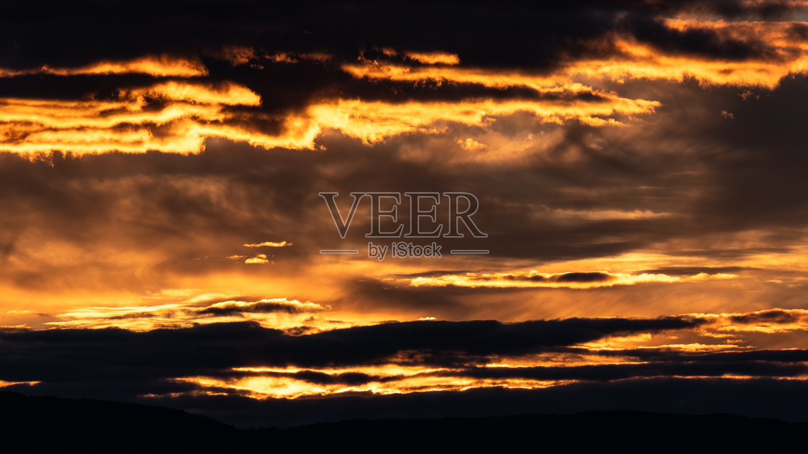 灿烂的日落看起来像天空中流动的熔岩照片摄影图片