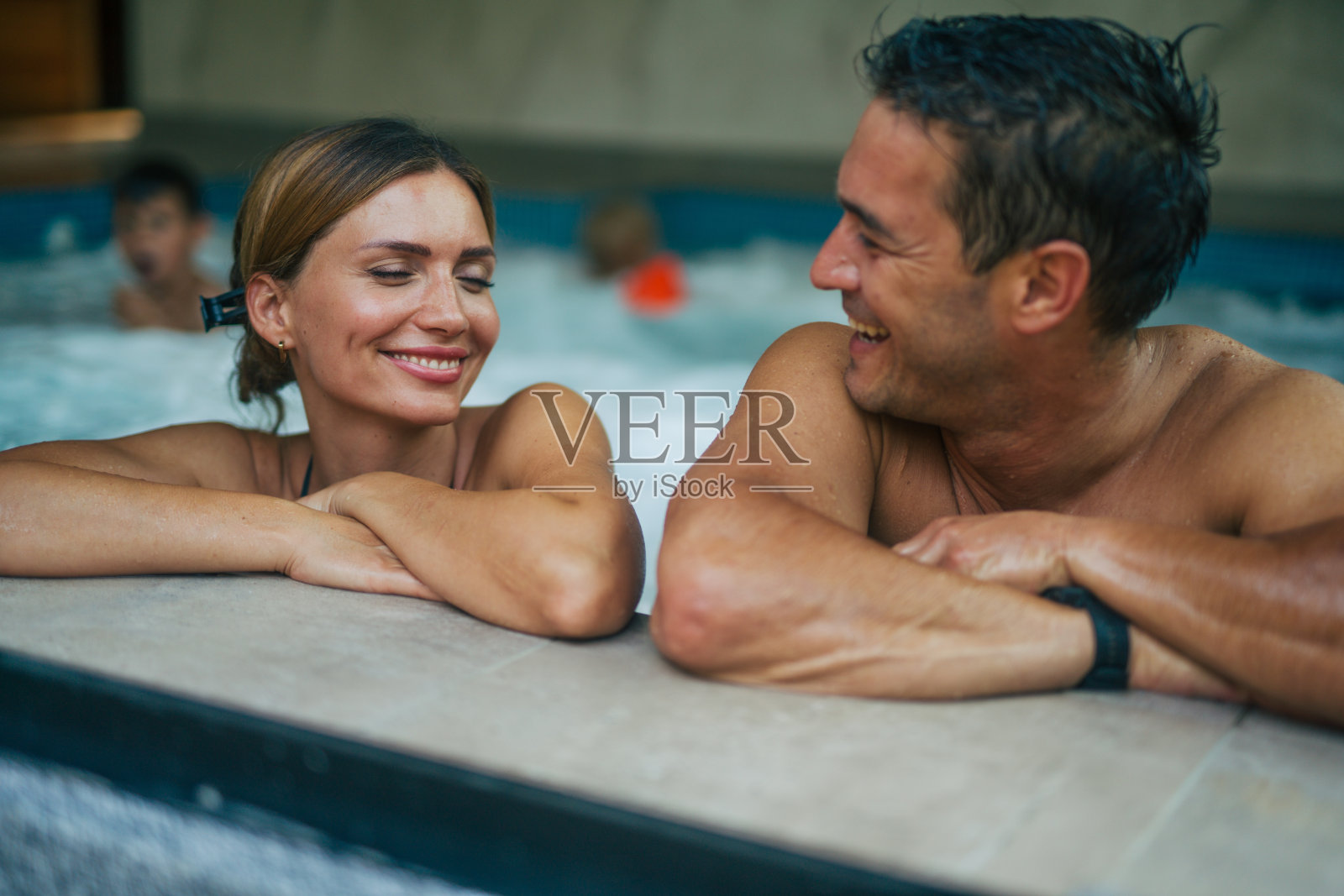 家庭度假时在室内泳池放松照片摄影图片