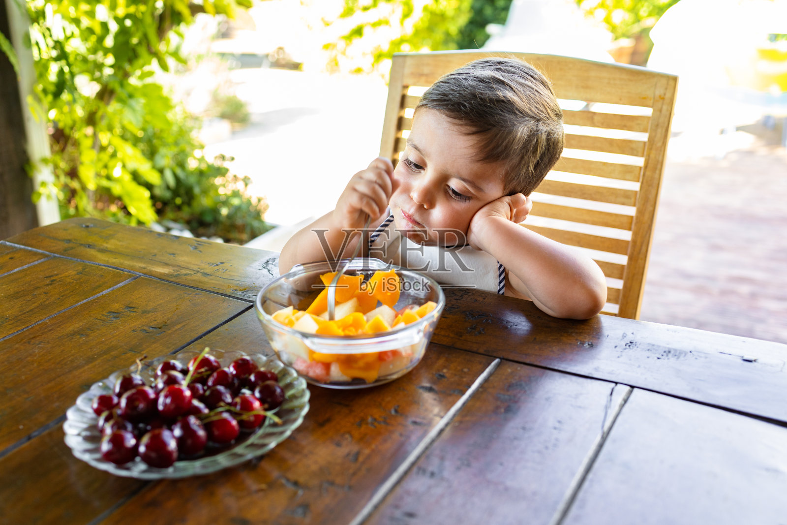 男孩在花园里享受健康的水果小吃照片摄影图片