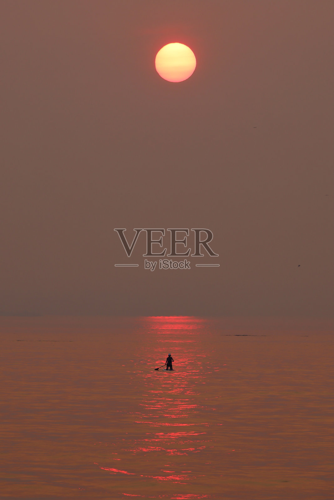 在华盛顿州普吉特海湾的野火烟雾中站立桨板照片摄影图片