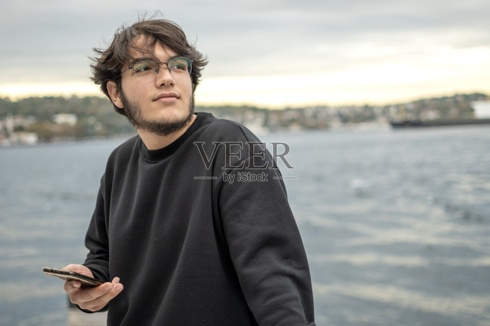 帅哥在户外玩手机照片摄影图片