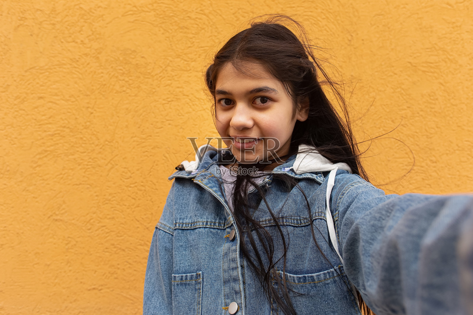 一个快乐的少年。一个十几岁的女孩自拍时的积极和微笑的情绪。照片摄影图片