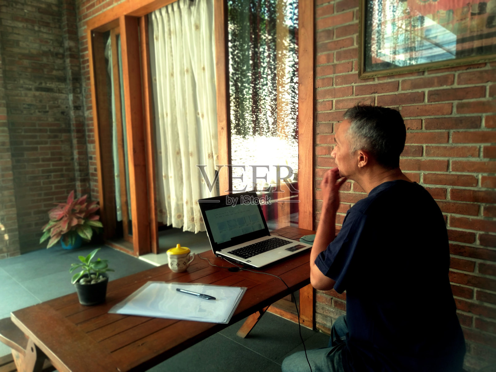 一个男人专注于笔记本电脑。照片摄影图片