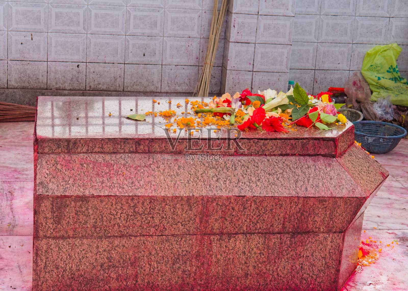 在印度的一座寺庙里，红色的桌面贝迪与鲜花一起被供奉的静态图像照片摄影图片