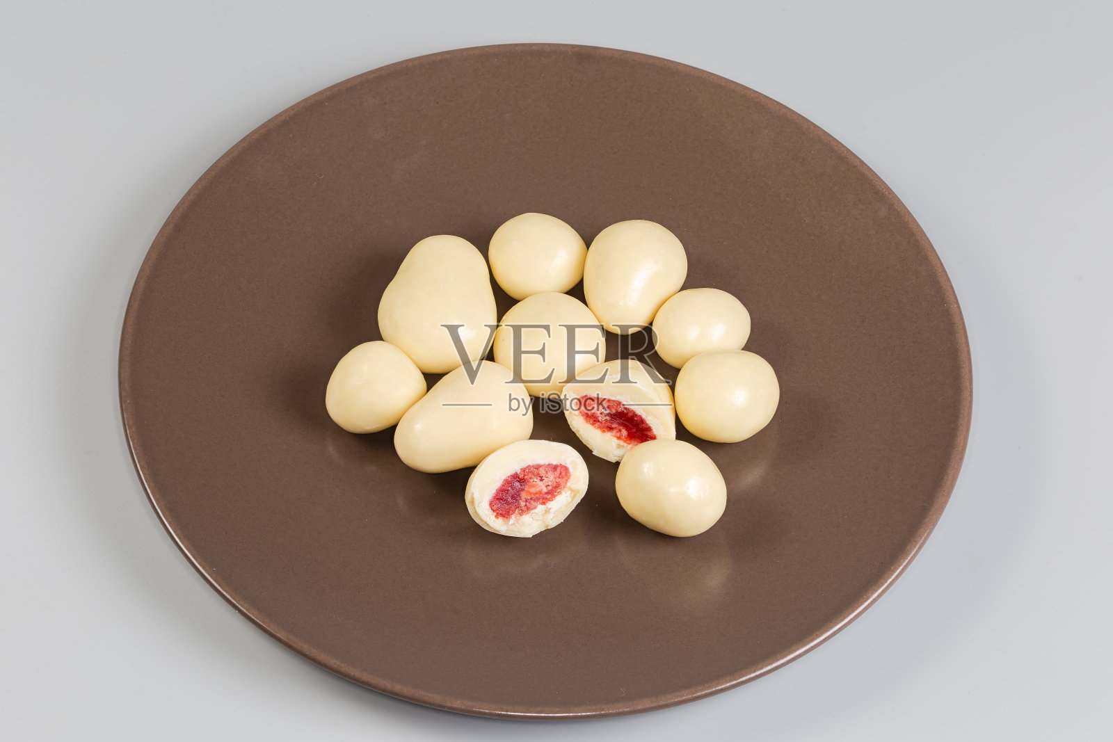 棕色盘子里的草莓干上裹着白巧克力照片摄影图片