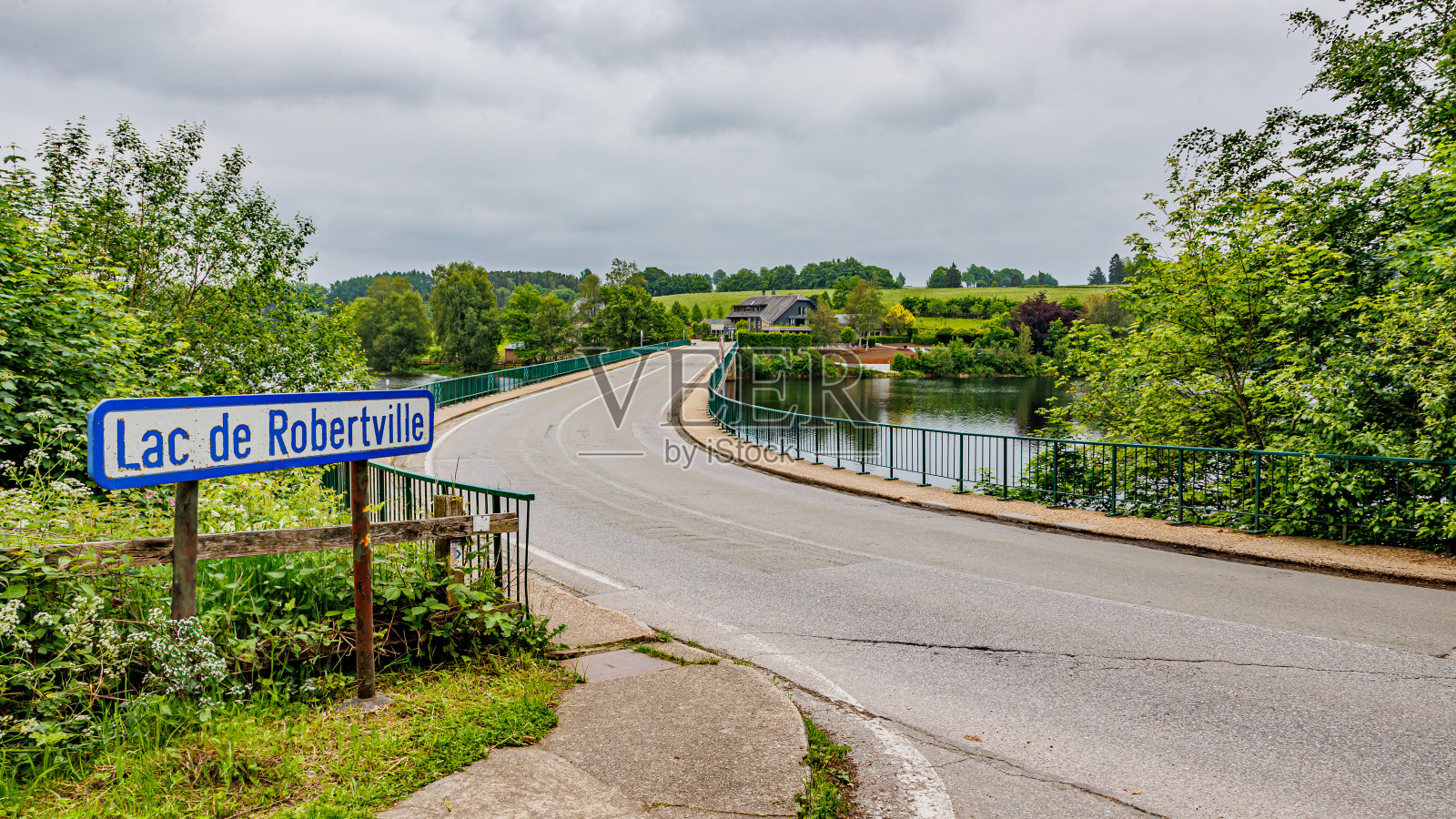 乡村公路通往罗伯特维尔湖上的车桥，标志上有法语湖名照片摄影图片