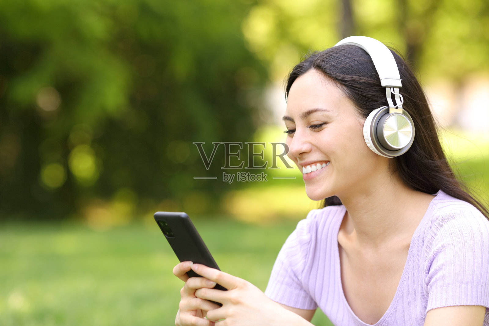 快乐的亚洲女人在公园里上网听音频照片摄影图片