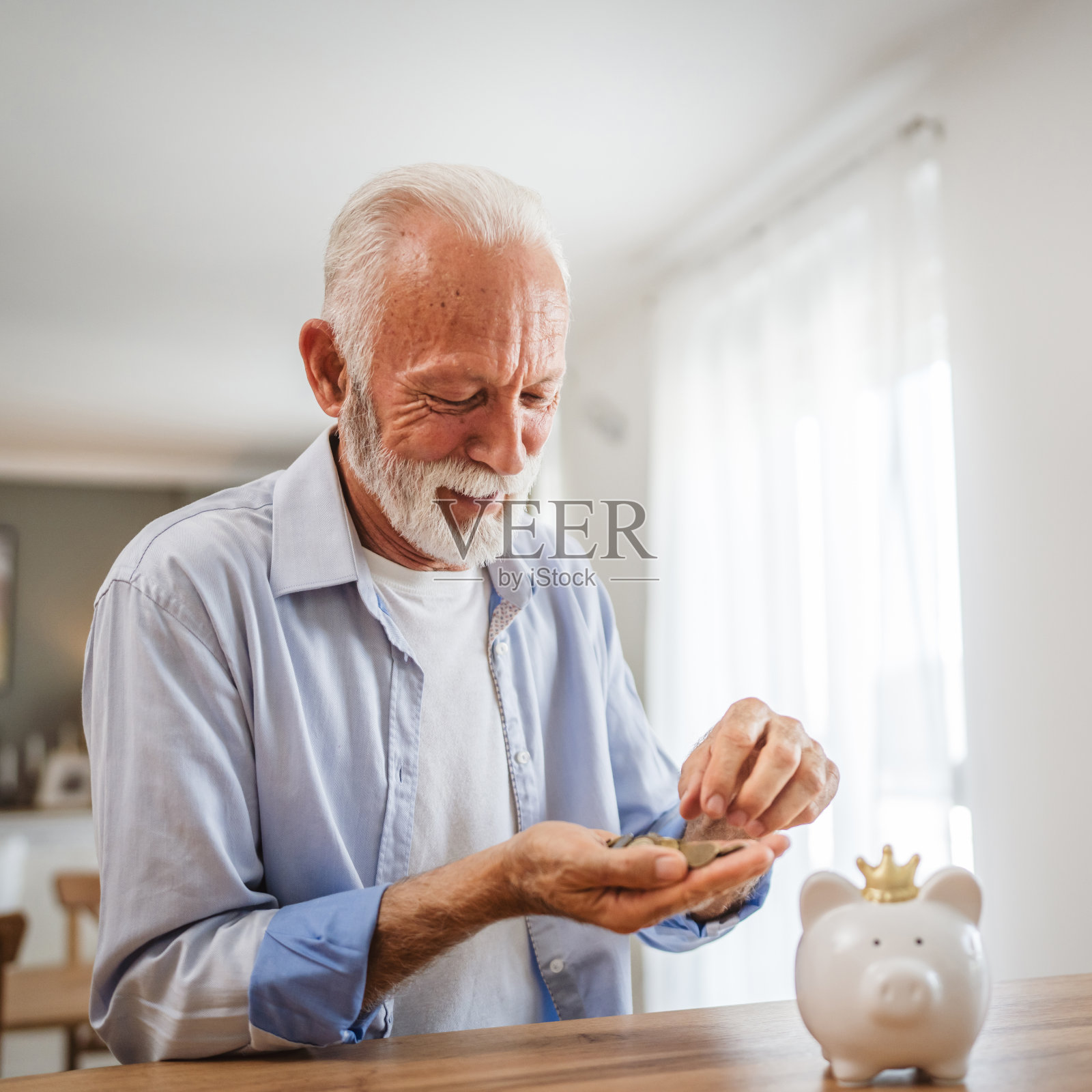 老人从扑满里数钱，把钱存到家里照片摄影图片