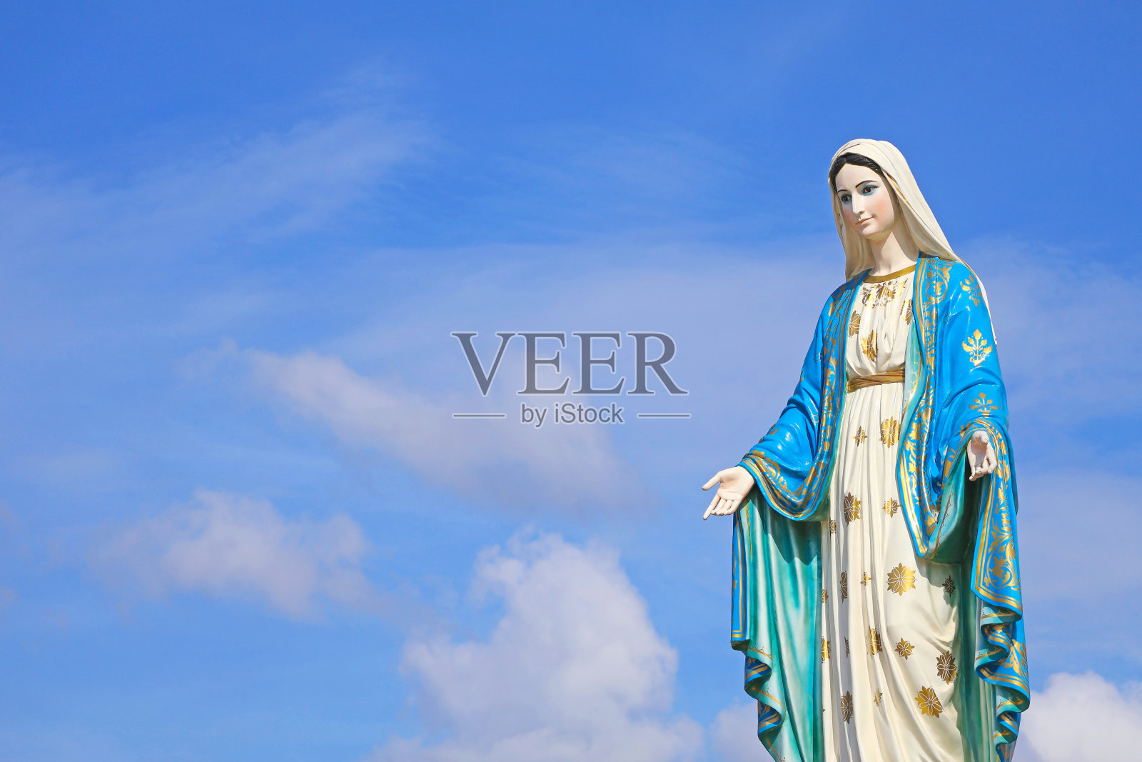 华丽的圣玛丽雕塑，上帝的母亲在阳光天空的背景照片摄影图片