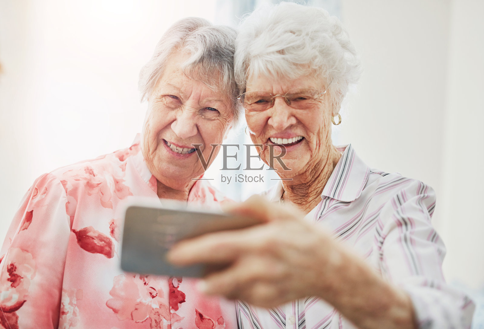 老年人、女性和朋友或喜欢自拍作为个人资料、回忆或退休后的拜访。老人，还是微笑着拍照与亲情、团聚、支持与关怀在养老院照片摄影图片