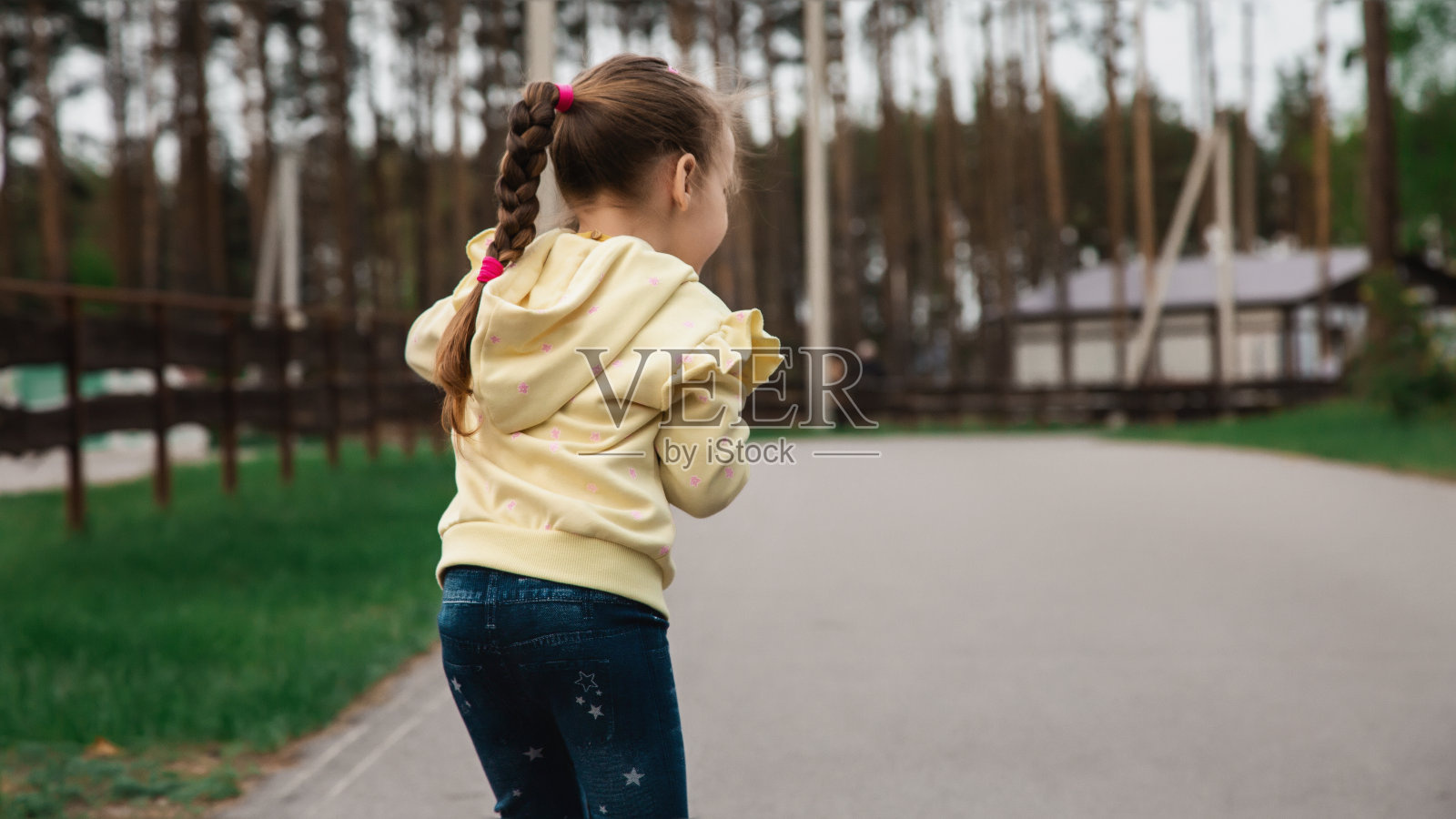 一个小女孩在公园里骑着摩托车。孩子们的春天活跃娱乐。副本的空间。照片摄影图片