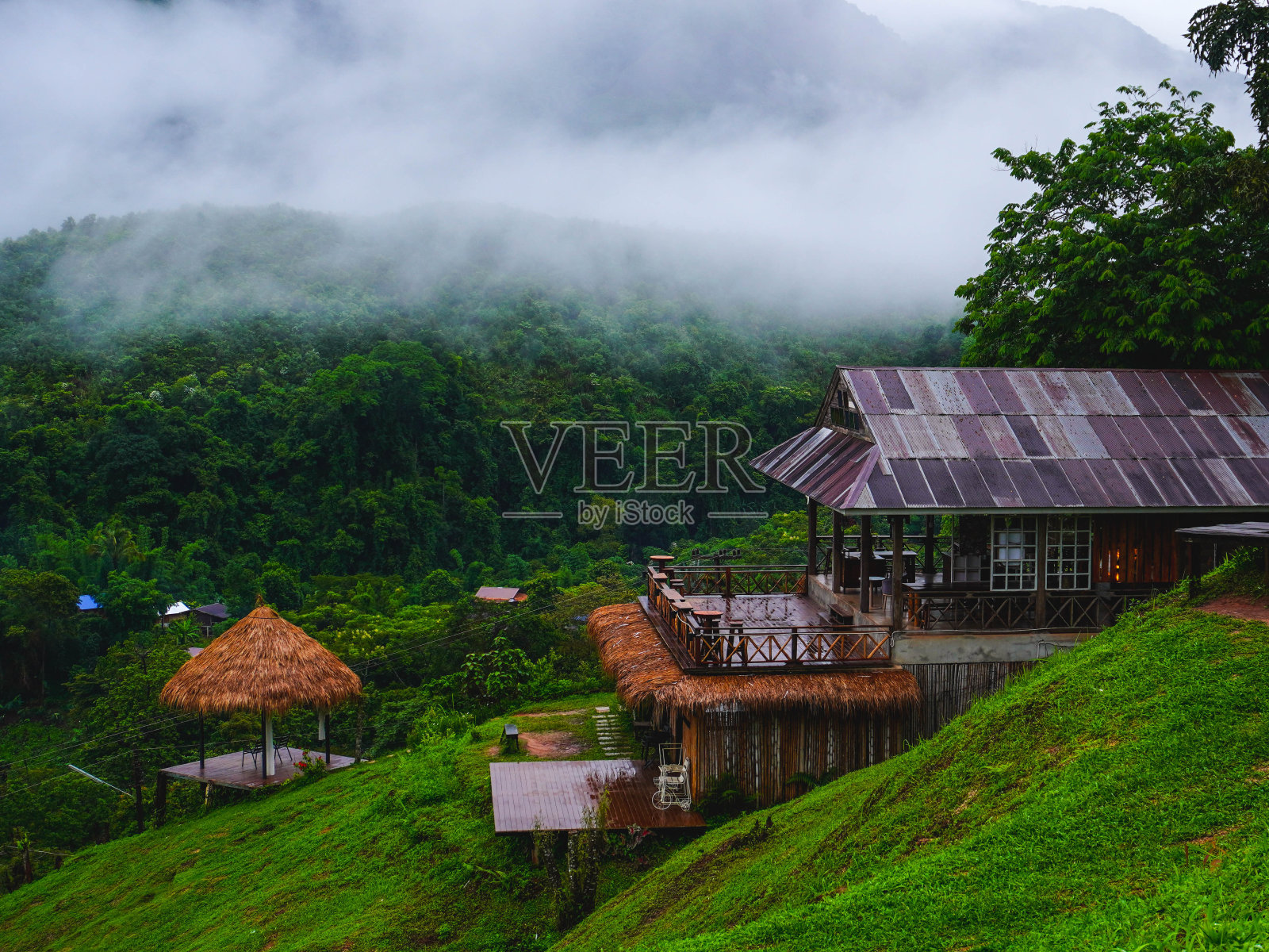 宾馆在美丽的萨潘村，一个小村庄在山谷中间，在泰国南省的雨季被大自然包围。照片摄影图片