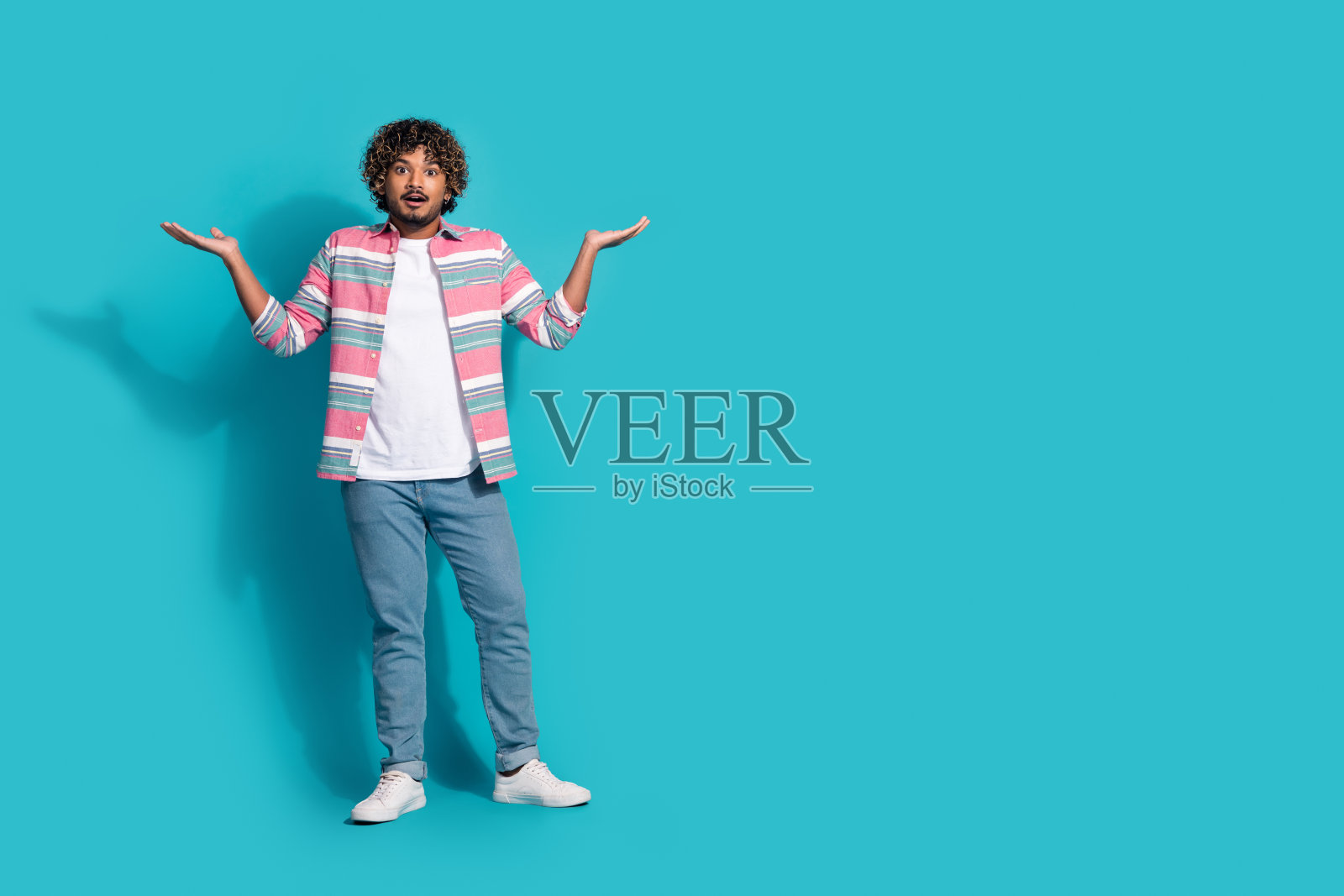 一个穿着时髦条纹衣服的开朗积极的男人的照片展示了青色背景上孤立的空白空间照片摄影图片