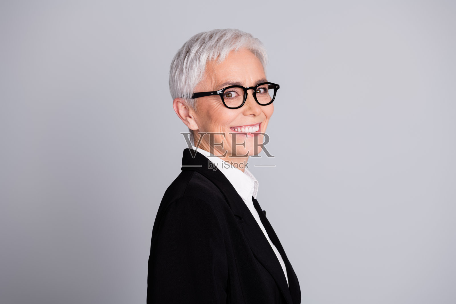 照片漂亮的资深女性专业企业家简介牙齿微笑穿着正装眼镜孤立在灰色背景照片摄影图片