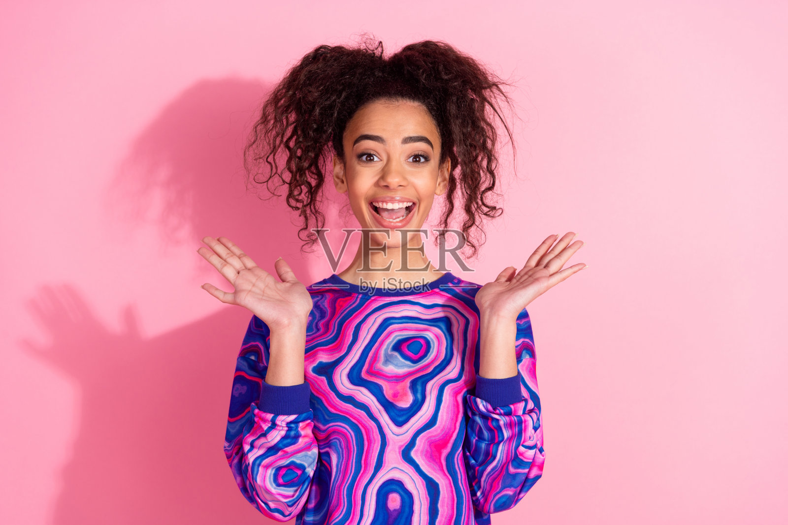 照片中兴奋迷人的女士穿着紫色运动衫微笑着，空白空间孤立的粉红色背景照片摄影图片